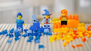 Lego Bauplatte mit drei Legofiguren und verschiedenen Legosteinen